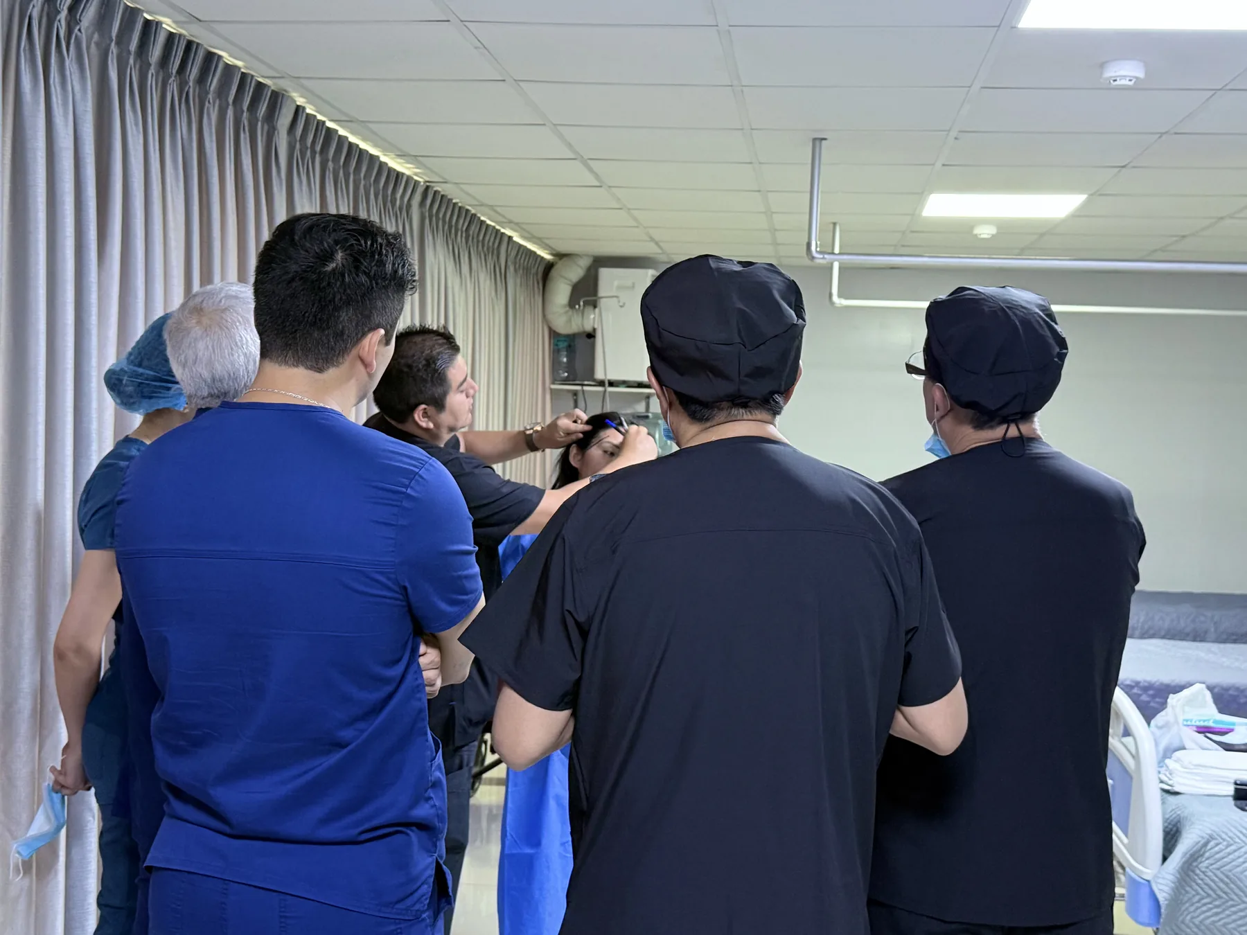 Grupo de cirujanos del fellowship reunido junto al Dr. Freddy Castillo durante la discusión de un caso