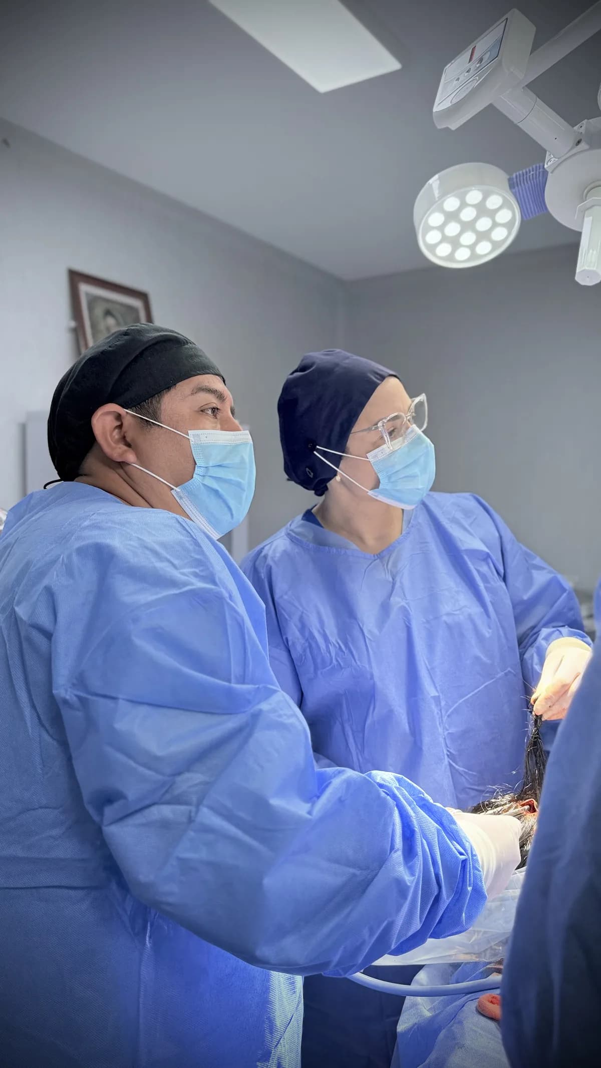Dr. Freddy Castillo durante una cirugía de rejuvenecimiento facial acompañado por una cirujana en formación