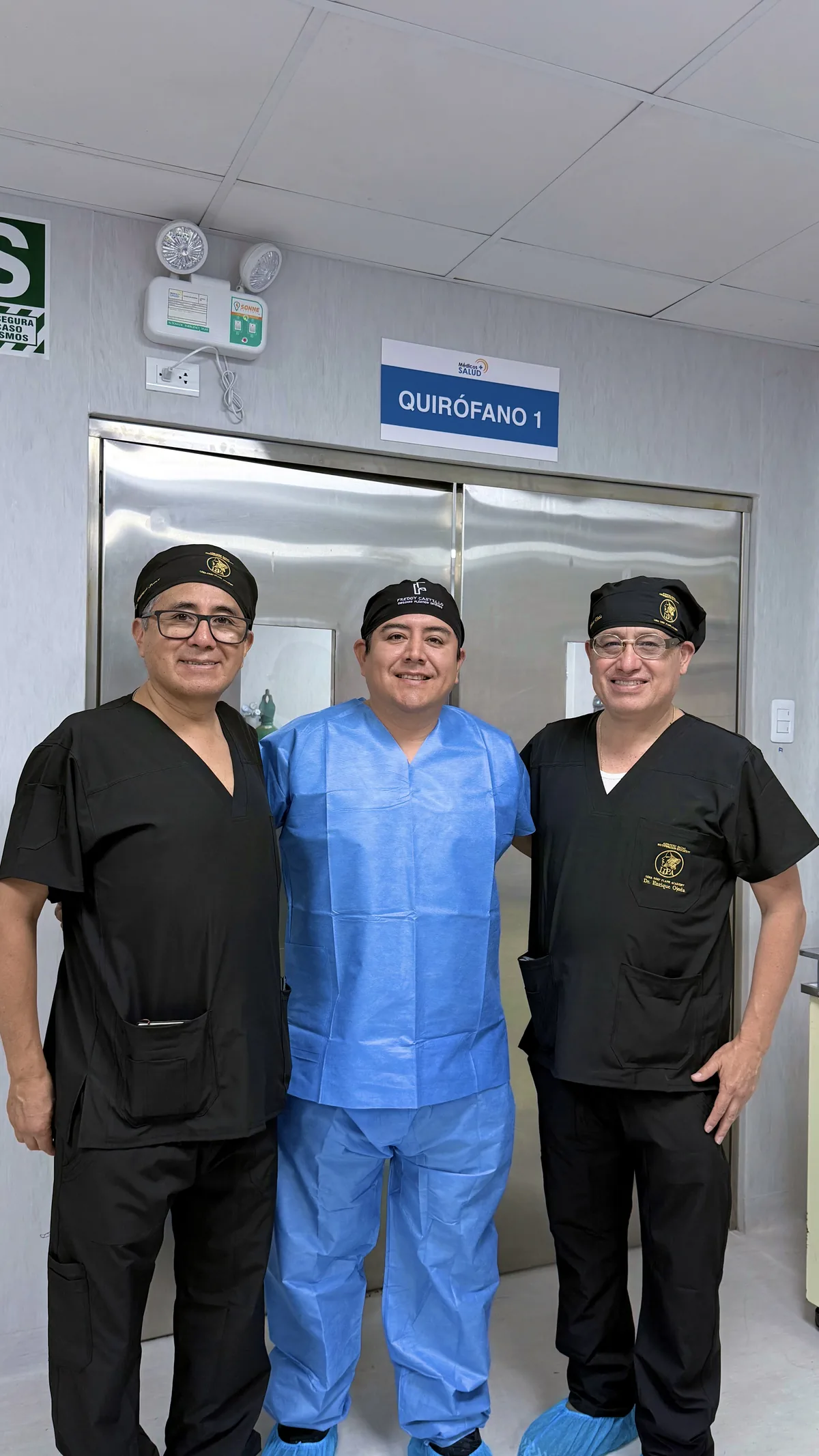 Dr. Freddy Castillo junto a dos cirujanos participantes frente al quirófano